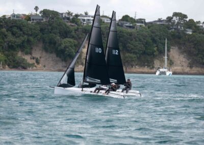Two sailboats racing near New Zealand coastline