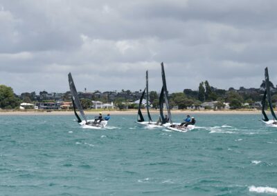 Sailboats racing near a New Zealand shoreline