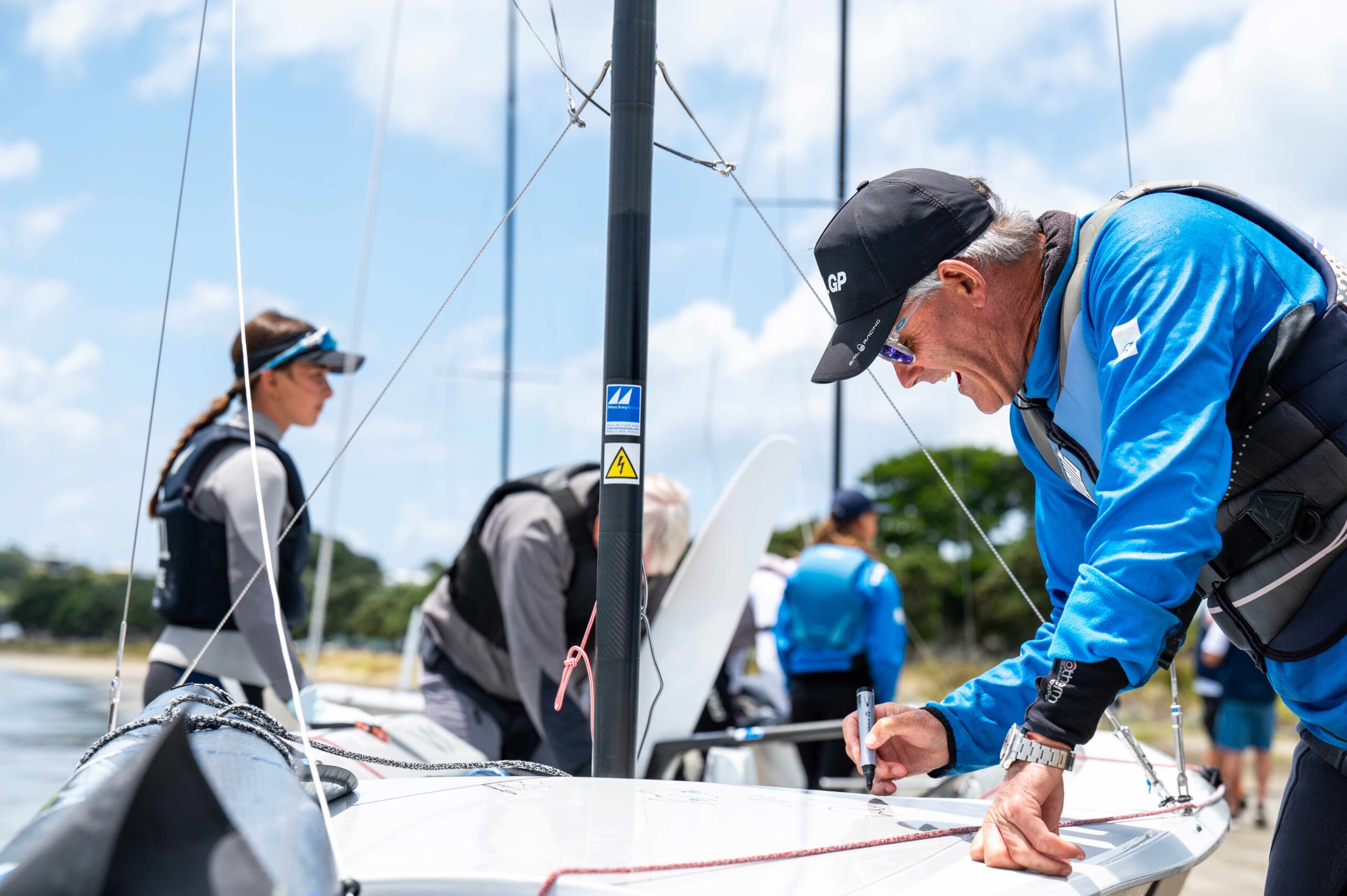 Sailors preparing boats by the water