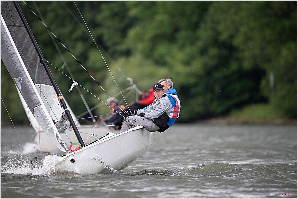 Two sailors racing a yacht on a windy lake