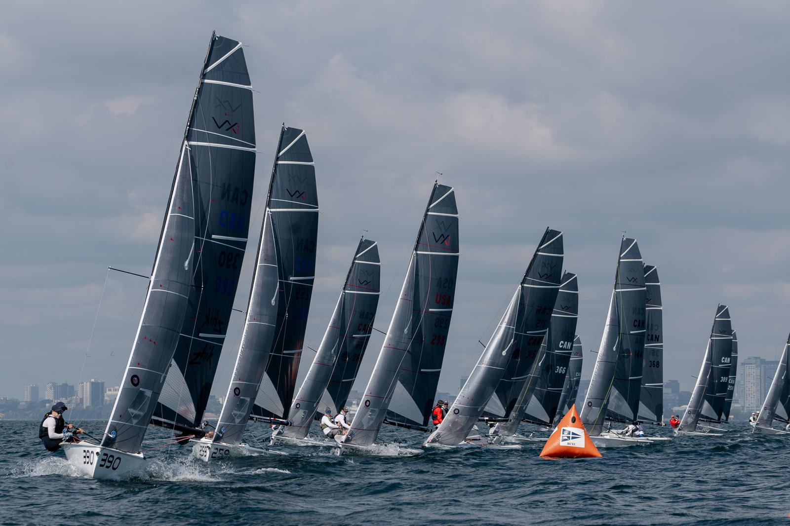 Sailboats racing near buoy on cloudy day